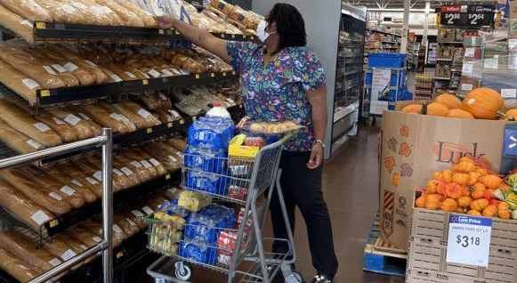 Caregiver grocery shopping for a Loving Arms client