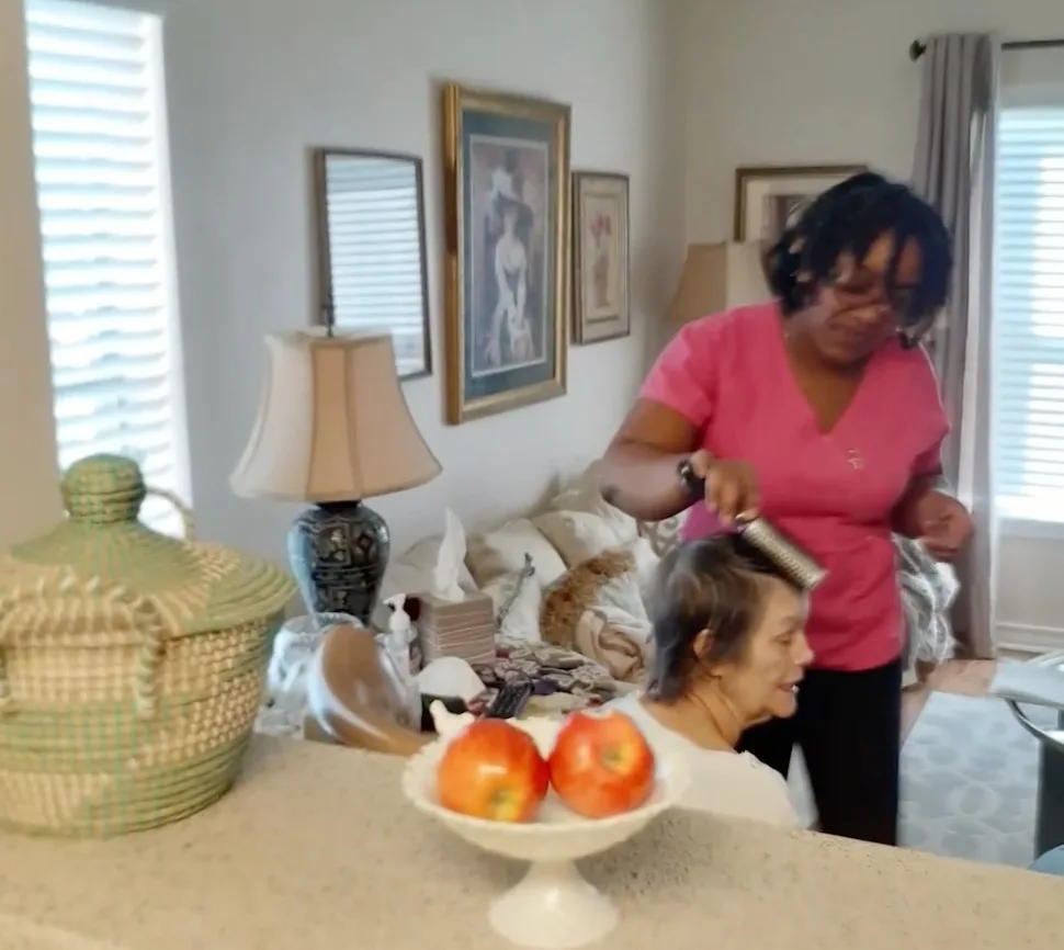 Caregiver helping client with personal grooming at home