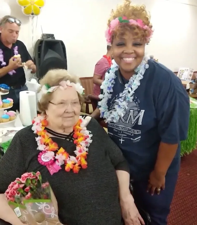 Caregiver and client at a Hawaiian-themed celebration